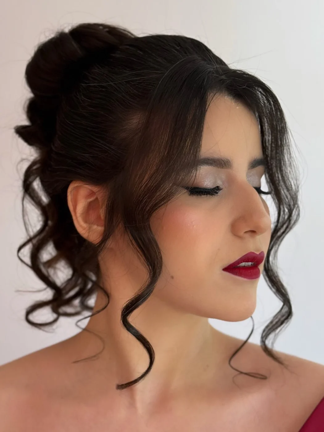 Cliente de coque com mechas cacheadas soltas, olhos esfumados e batom vermelho