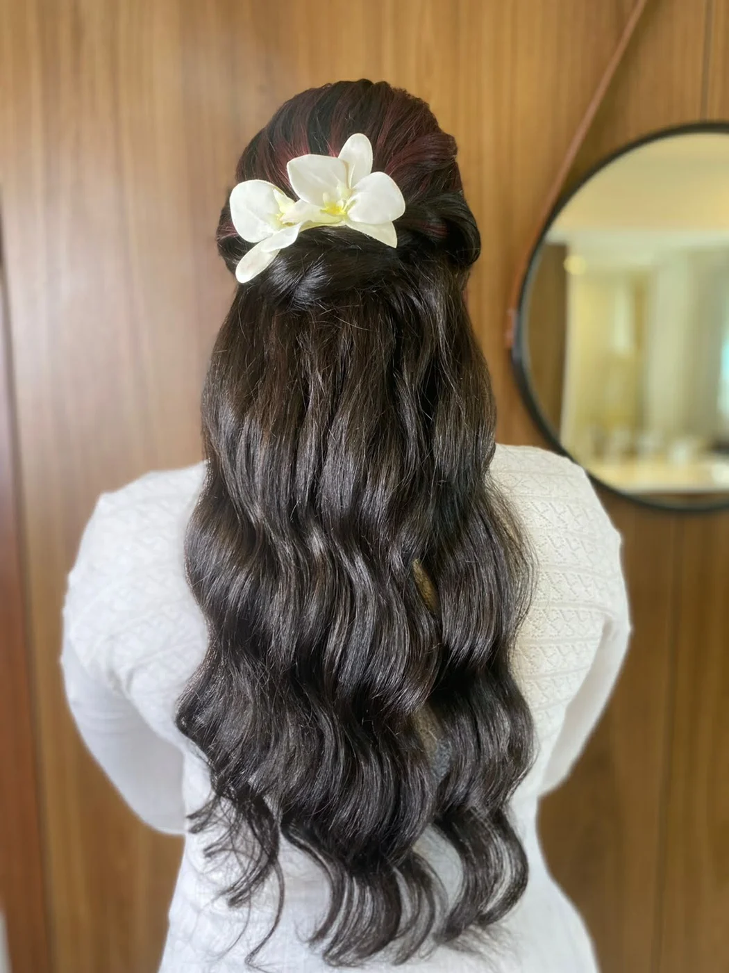 Semi-preso com uma orquídea branca e ondas longas escuras, visto de costas diante da porta de madeira