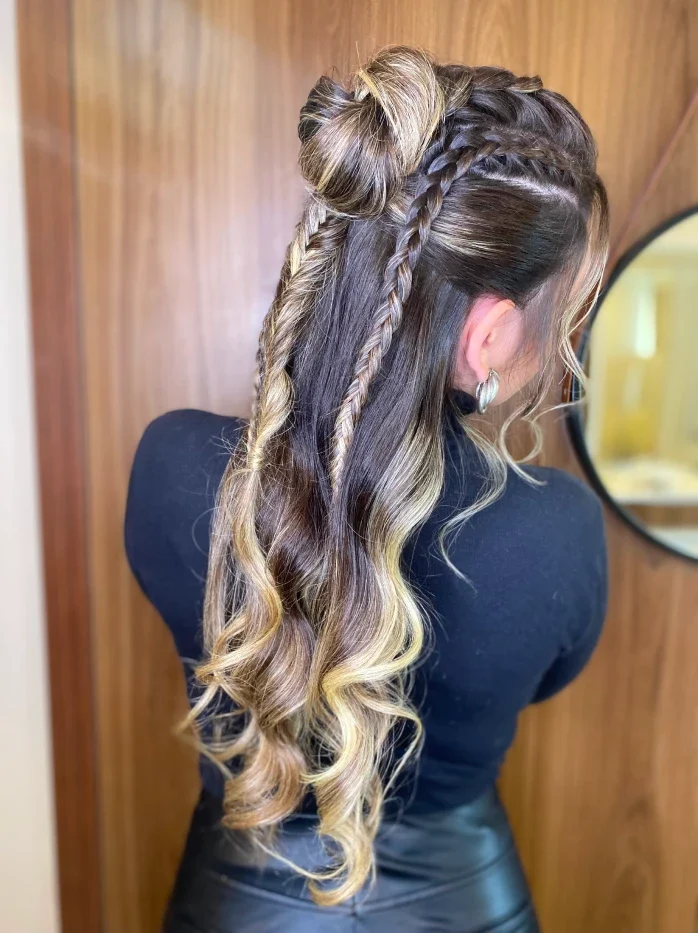 Dois pequenos coques com tranças e ondas longas com mechas loiras, vistos de costas